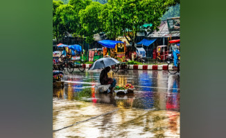 মুষলধারে বৃষ্টির মাঝেও তিনি বসে আছেন, কারণ ক্ষুধা কোনো ঋতু মানে না।
